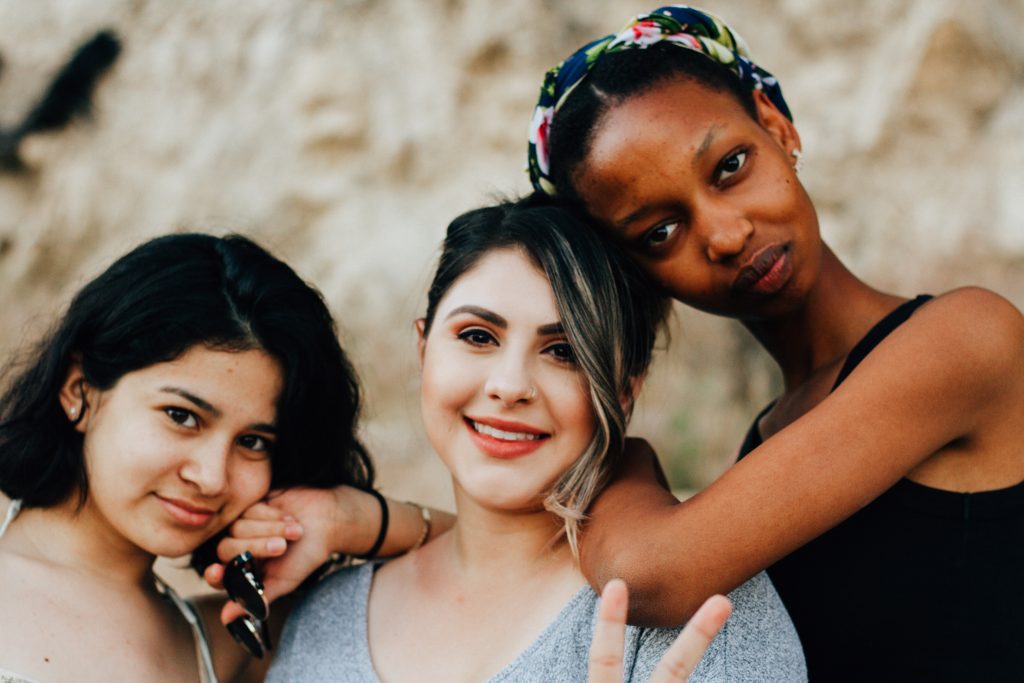 Three women standing together of different racial background